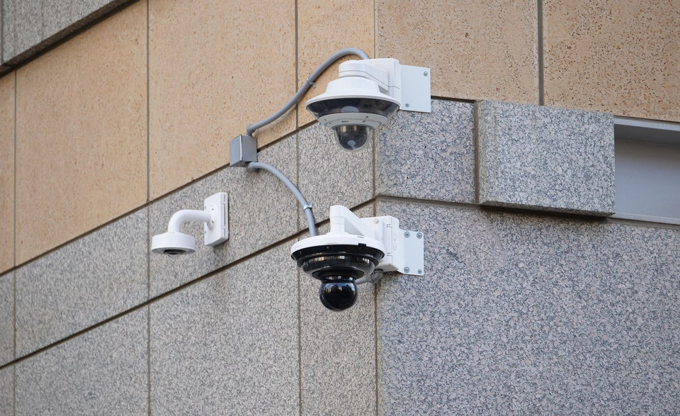 Outdoor pan tilt zoom security cameras on a building corner